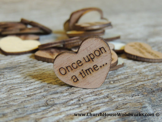 Rustic laser-cut wooden hearts with engraved phrases like 'Love' and 'Happily Ever After' scattered on a wedding table as decorative confetti
