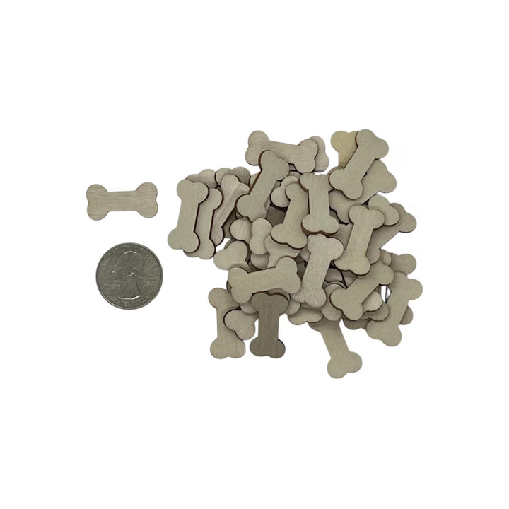 Small bone-shaped laser cut wood shapes with a coin for scale on a white background