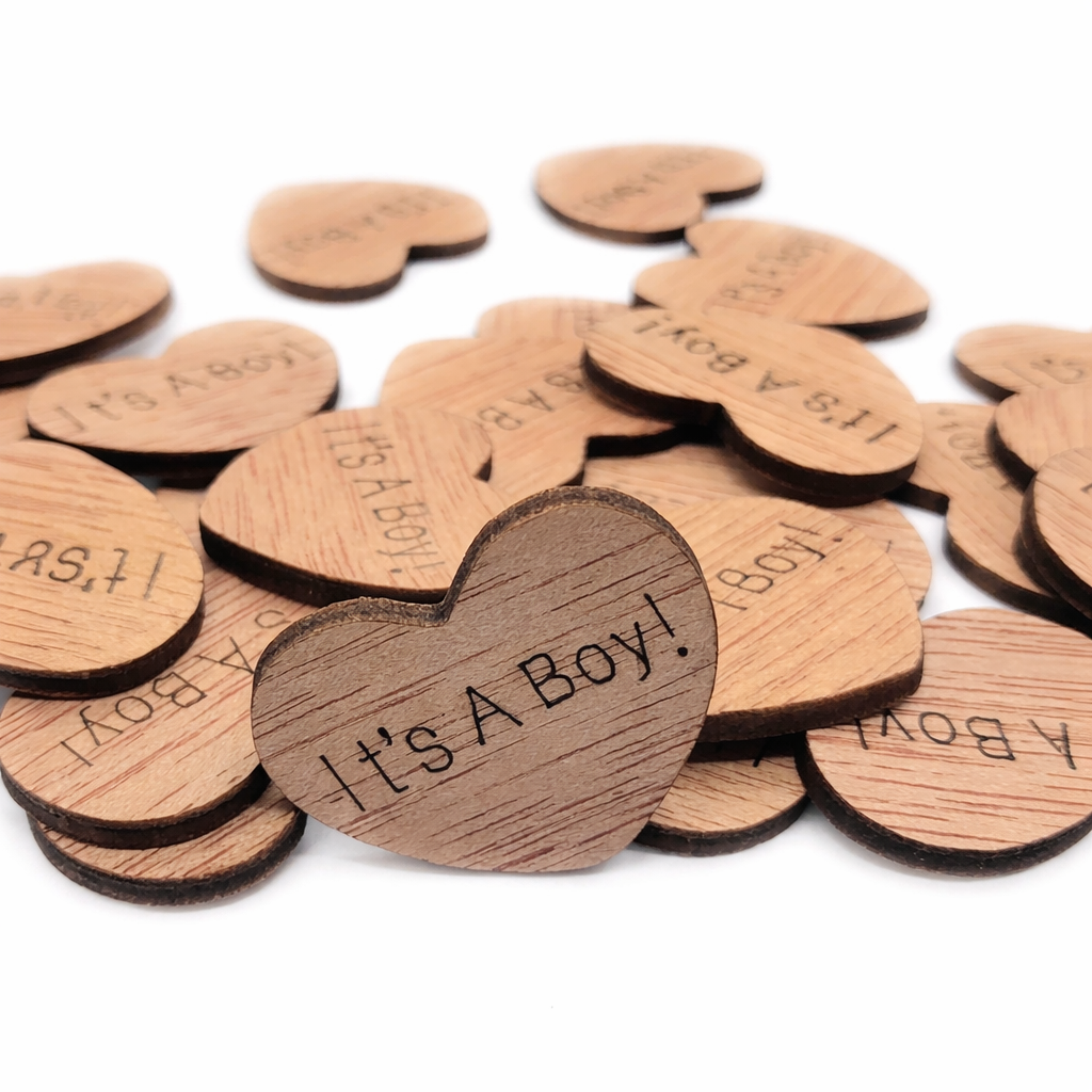 Wooden heart-shaped tokens with 'It's a Boy!' text on a white background