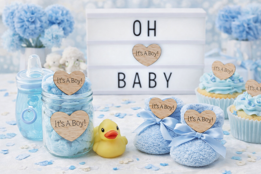 Baby shower decorations with 'It's a Boy!' signs, blue jars, socks, and a duck toy on a light background.