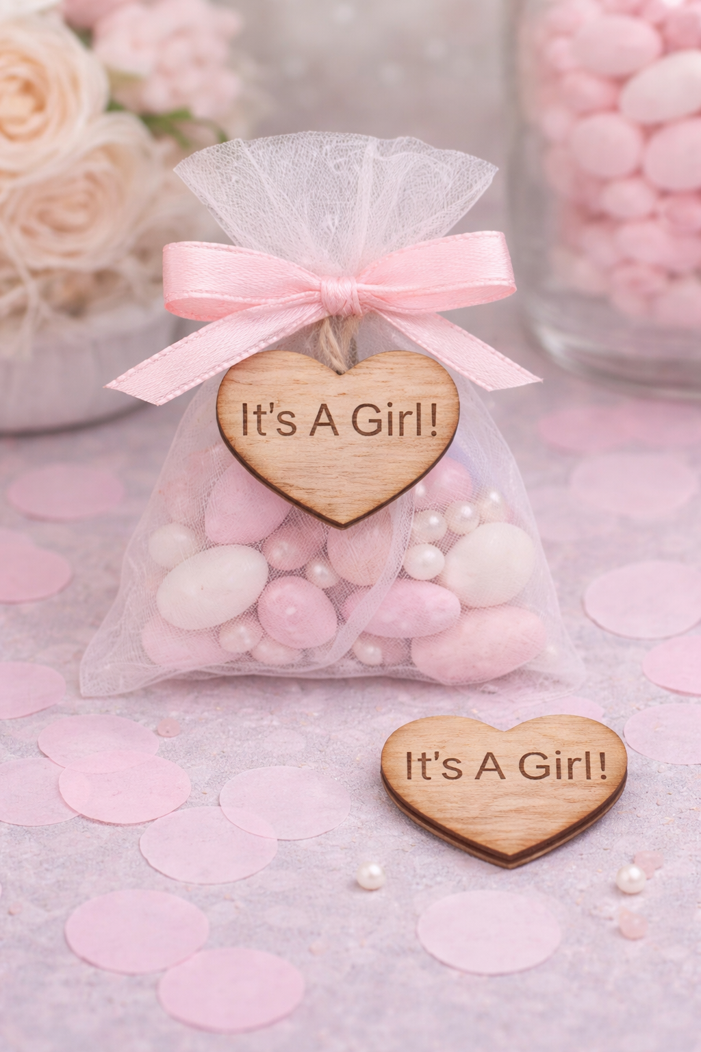 Pink candy bag with 'It's a Girl!' heart-shaped wooden tag on a pink background